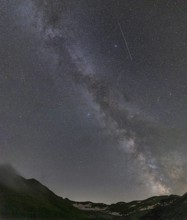 Nocturnal starry sky over the Furka Pass in the Swiss Alps. The night photograph shows the stars of