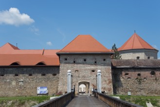 A historic fortress with red roofs under a clear blue sky, access via a bridge, Fortress, Fagaras,