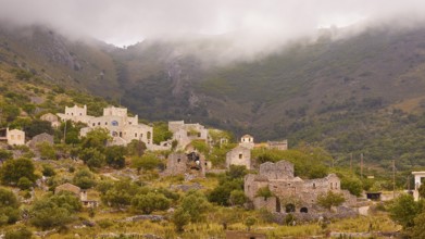 Village in the mist surrounded by mountains and greenery, Mani Peninsula, Peloponnese, Greece,