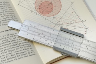 Slide rule on book, calculating aid