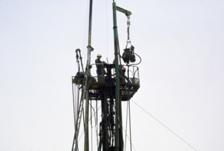 Men at work on a drilling rig in the oil exploration industry in the area of Dhahran, Saudi Arabia,