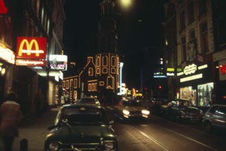 Neon lights in the city centre of Amsterdam at night, Netherlands 1970s 1980s, Macdonalds fast food