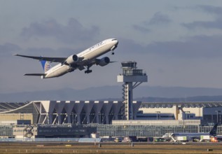 Aircraft taking off in front of the hangar and tower at Fraport Airport in Frankfurt. Aircraft