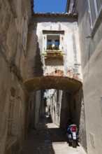 Narrow cobbled alley with flowers at the window and motorbike, Old Town, Krk Town, Krk Island,