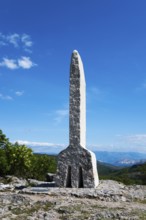 Stone pillar in a wooded landscape rising against a clear blue sky, Glagolitsa, the oldest script