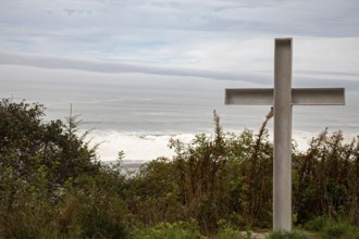 Klamath, California - A cross stands on a hill above the Pacific Ocean near a small cemetery on the