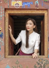 Woman looks out the window at Wat Xieng Thong, Luang Prabang, Laos, Asia