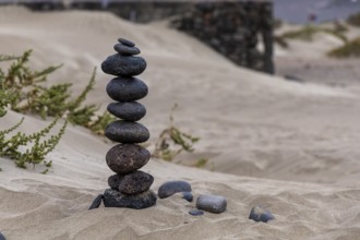 An artfully stacked tower of stones in a sandy landscape, Canary Islands, Lanzarote, Spain, Europe