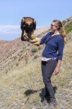 Young tourist with an eagle on her hand, near Kysyl-Suu, Issyk Kul, Kyrgyzstan, Asia