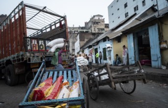 Labourer carries good from truck at a wholesale market, ahead of the presentation of the Interim