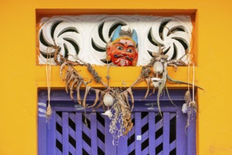 Purple-coloured front door, yellow wall, house entrance with demon mask, Rameswaram or Rameshwaram,