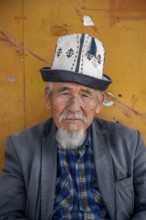 Portrait, Local man with traditional hat waiting at a bus stop, Issyk-Kul region, Kyrgyzstan, Asia