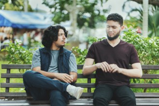 Man smoking cigarette near people in public. Man smoking and exhaling smoke to another person near