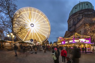 Ferris wheel at the winter village, Christmas market at dusk, St Elisabeth's Church on the right,