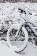 All wheels stand still If it is the winters will. A snow covered bicycle parked