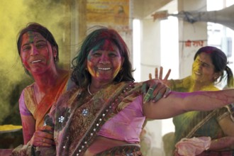 Women covered in colourful dye celebrating the Holi festival, Festival of Colours in Mathura, Uttar