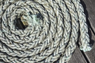 Close up of coiled braided rope, plaited hawser on deck