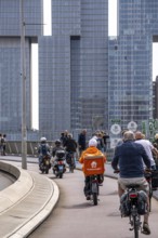 Cyclist on the cycle path of the Erasmus Bridge over the Nieuwe Maas, skyline of the skyscrapers on