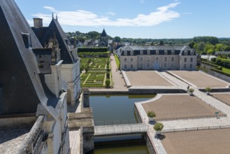 Tranquil castle complex with manicured gardens and a moat under a clear blue sky, Villandry Castle,