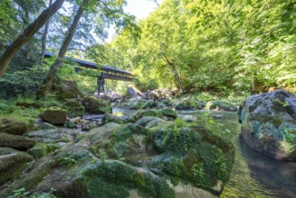 The Irrel Waterfalls, rapids in the lower reaches of the Prüm, covered wooden bridge for hikers,