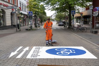 Application of road markings for a cycle lane, Rüttenscheider Straße in Essen, in the shopping and