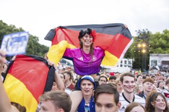 Celinda celebrates with a German flag on her boyfriend's shoulders in the fan zone at the