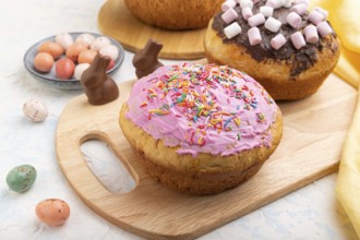 Homemade glazed and decorated easter pies with chocolate eggs and rabbits on a white concrete