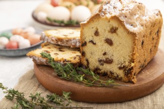 Homemade easter pie with raisins and eggs on plate on a gray concrete background and linen textile.