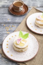 Decorated cake with milk and coconut cream with cup of coffee on a gray wooden background and linen