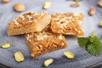 Traditional arabic sweets in gray ceramic plate on a gray concrete background. side view, close up,