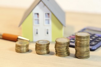 Concept photo with model house and coins