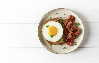 Breakfast, fried egg with bacon, micro-green, on a light background, no people, selective focus