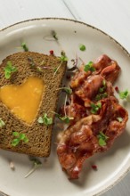 Breakfast, fried egg with bacon, micro-green, on a light background, no people, selective focus