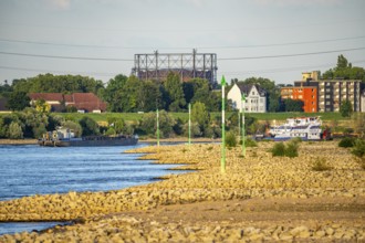 Cargo ship at low water on the Rhine near Duisburg-Homberg, view of Duisburg-Laar, houses on