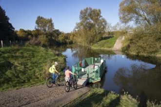 Cyclist, cycle tour, manually operated ferry across the Lippe near Halten am See, on the