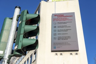 Advertising display on a house wall with information on corona, effects of the coronavirus pandemic