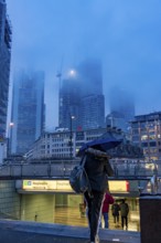 Rainy weather, freezing rain, entrance to Hauptwache underground station, high-rise skyline in