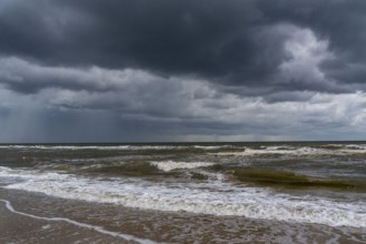 Beach, dark storm clouds, choppy sea, autumn on the North Sea in North Holland, between the towns