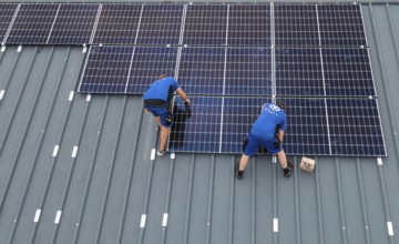 Installation of solar modules on the roof of a barn on a farm, over 240 photovoltaic modules are