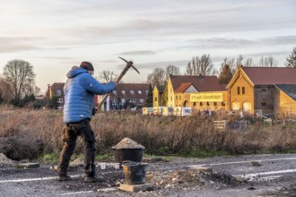 Climate activists chop up the asphalt of a road to erect obstacles, barricades, to prevent the