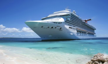 A large cruise ship is docked at the beach. The ship is white and is surrounded by a blue ocean.