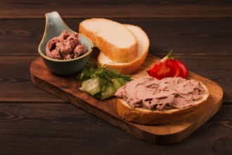 Liver meat pate spread, on white bread, on a wooden background, breakfast, close-up, no people,