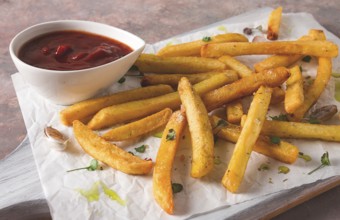 Fried French fries, in a paper bag, on an abstract background, no people, rustic