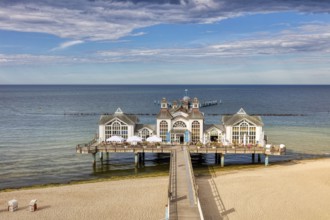 Historic pier on the Baltic Sea with long wooden walkway and picturesque sky, Rügen