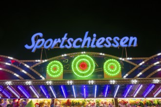 Illuminated sports shooting sign on a fairground stand with colourful lights at night, Cannstatter