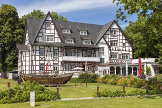 Half-timbered house with well-tended garden and a decorative wooden boat on the lawn, Rügen,