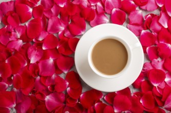 Red rose petals background and a cup of coffee. Morninig, spring, fashion composition. Flat lay,