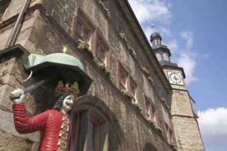 Roland sculpture and old town hall with tower, figure, view from below, man with crown and sword,