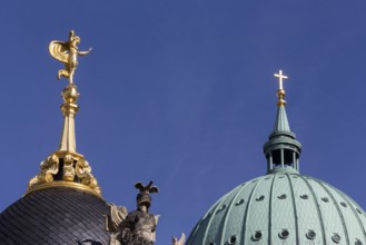 Fortuna portal with sculpture on the top and behind it a cross on the dome of the Nikolaikirche in