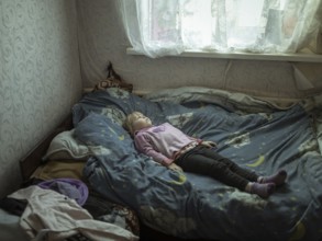 Angelina, 9 years old, on her bed. The village of Borshchivka was under Russian occupation. She has